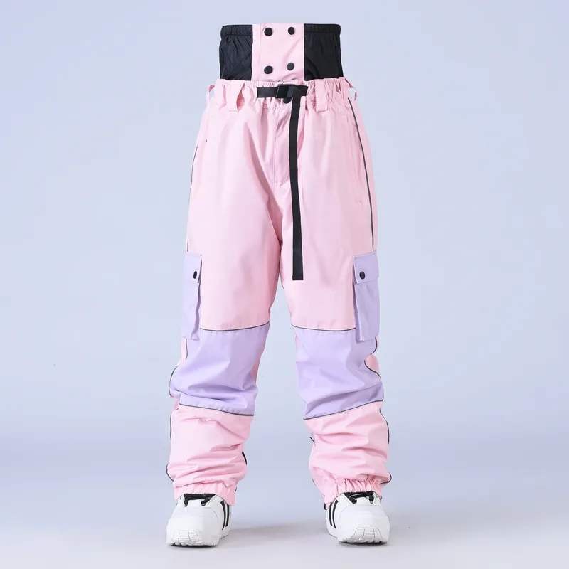 Unisex baggy snowboard pants in Pink — baggy fit with cargo pockets and reflective trim, worn by a model