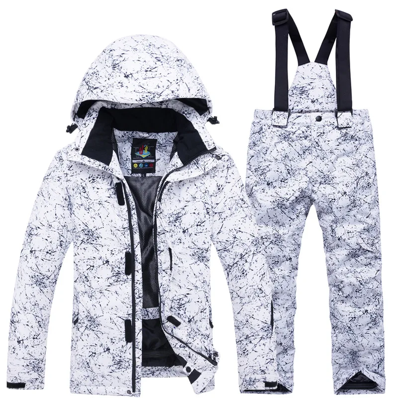 Girls' ski set in a white ink-splatter print — hooded jacket and matching bib pants