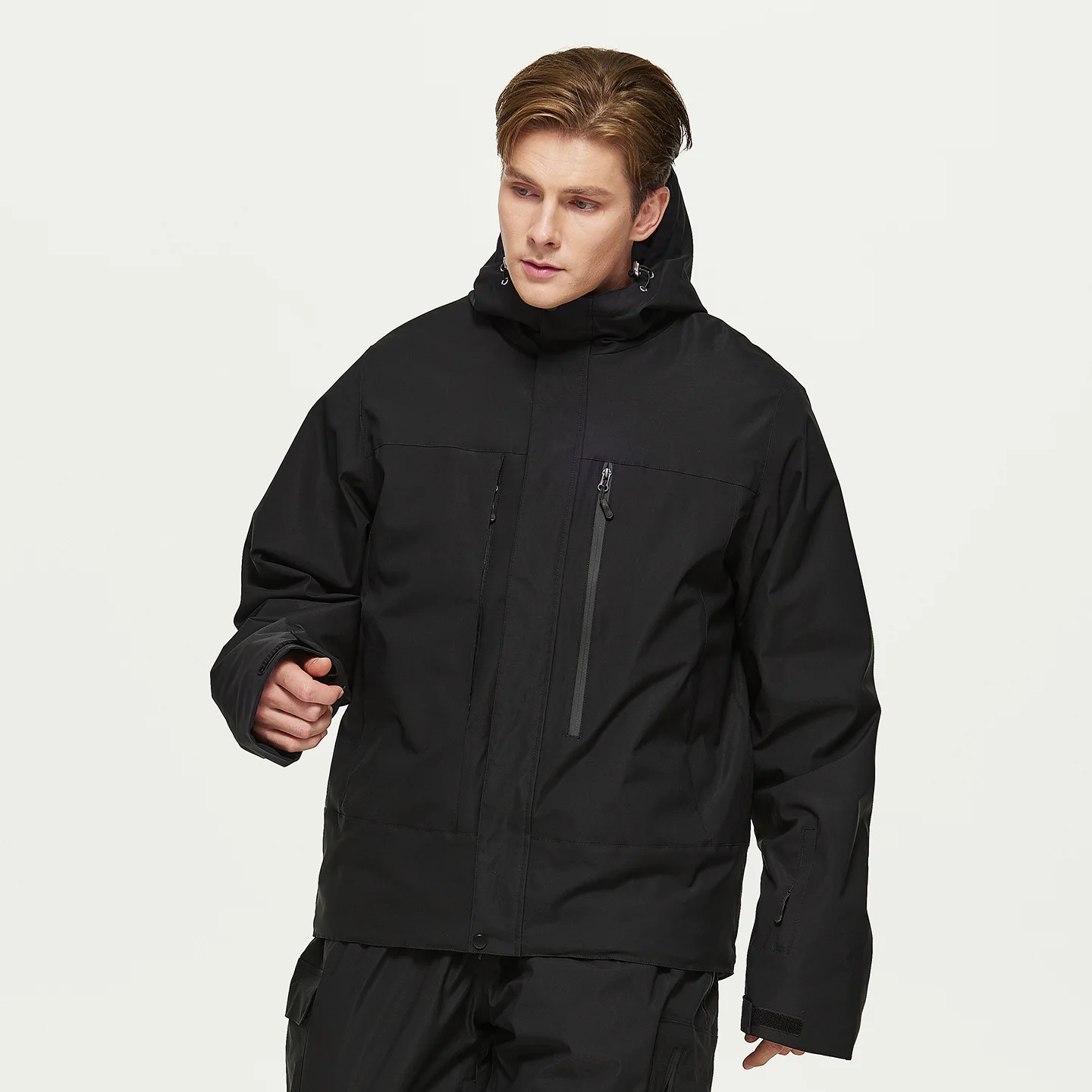 Man wearing the men’s insulated ski jacket in Black with PP cotton fill and an attached hood