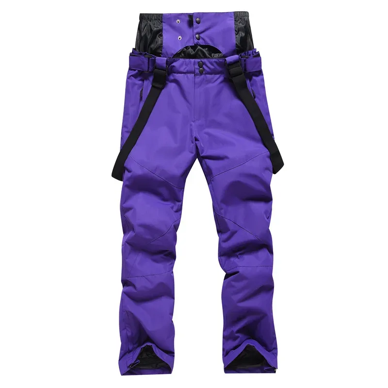 Unisex ski bib pants in Dark Purple — adjustable suspenders and a relaxed leg, flat lay