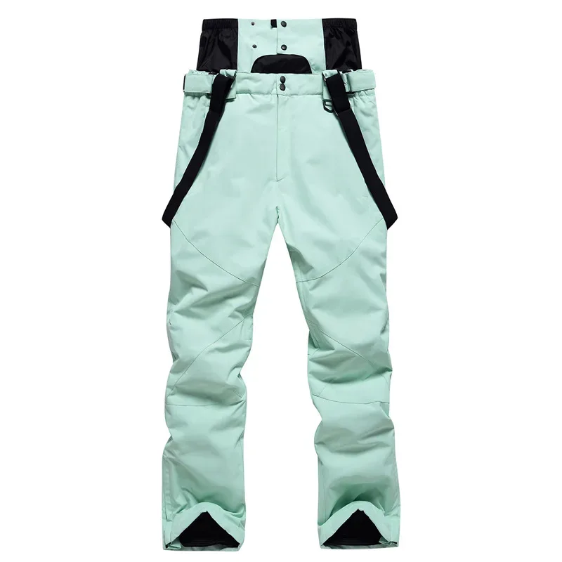 Unisex ski bib pants in Light Green — adjustable suspenders and a relaxed leg, flat lay