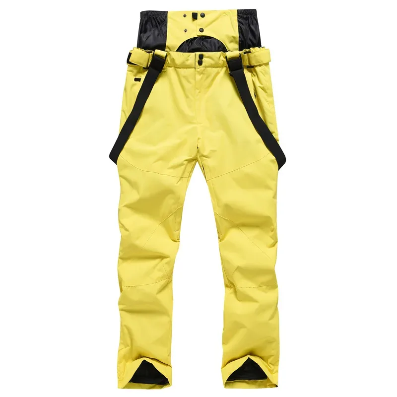 Unisex ski bib pants in Yellow — adjustable suspenders and a relaxed leg, flat lay