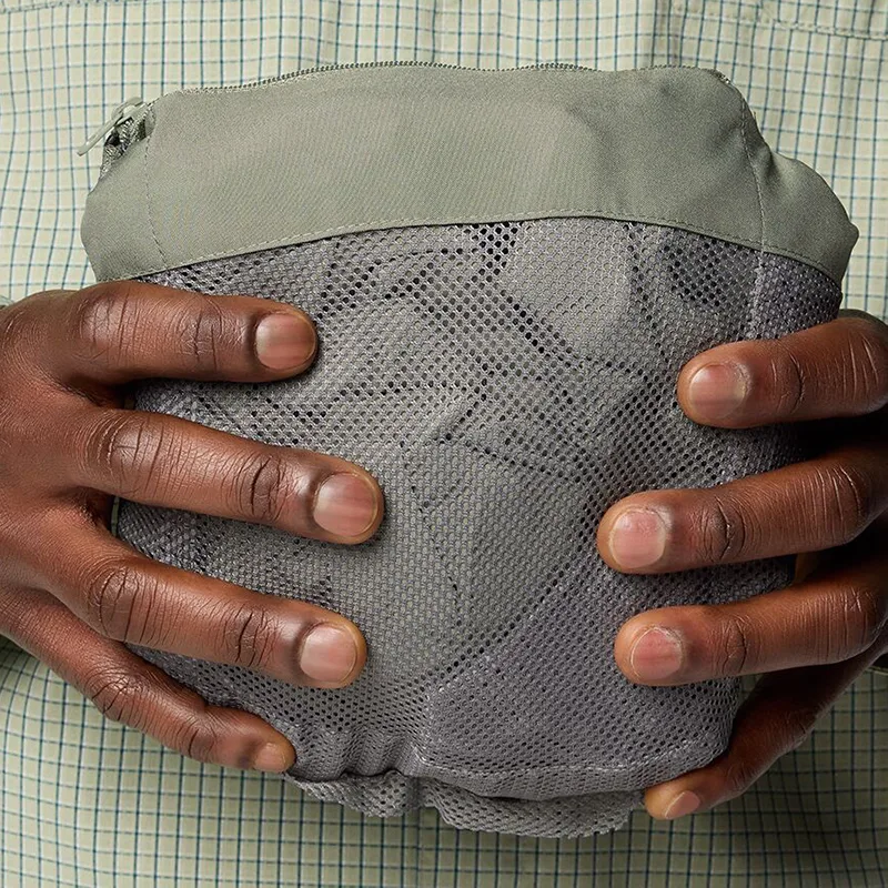 Unisex Hardshell Jacket — Light Green & Black — Light Green, packed into its pocket, detail