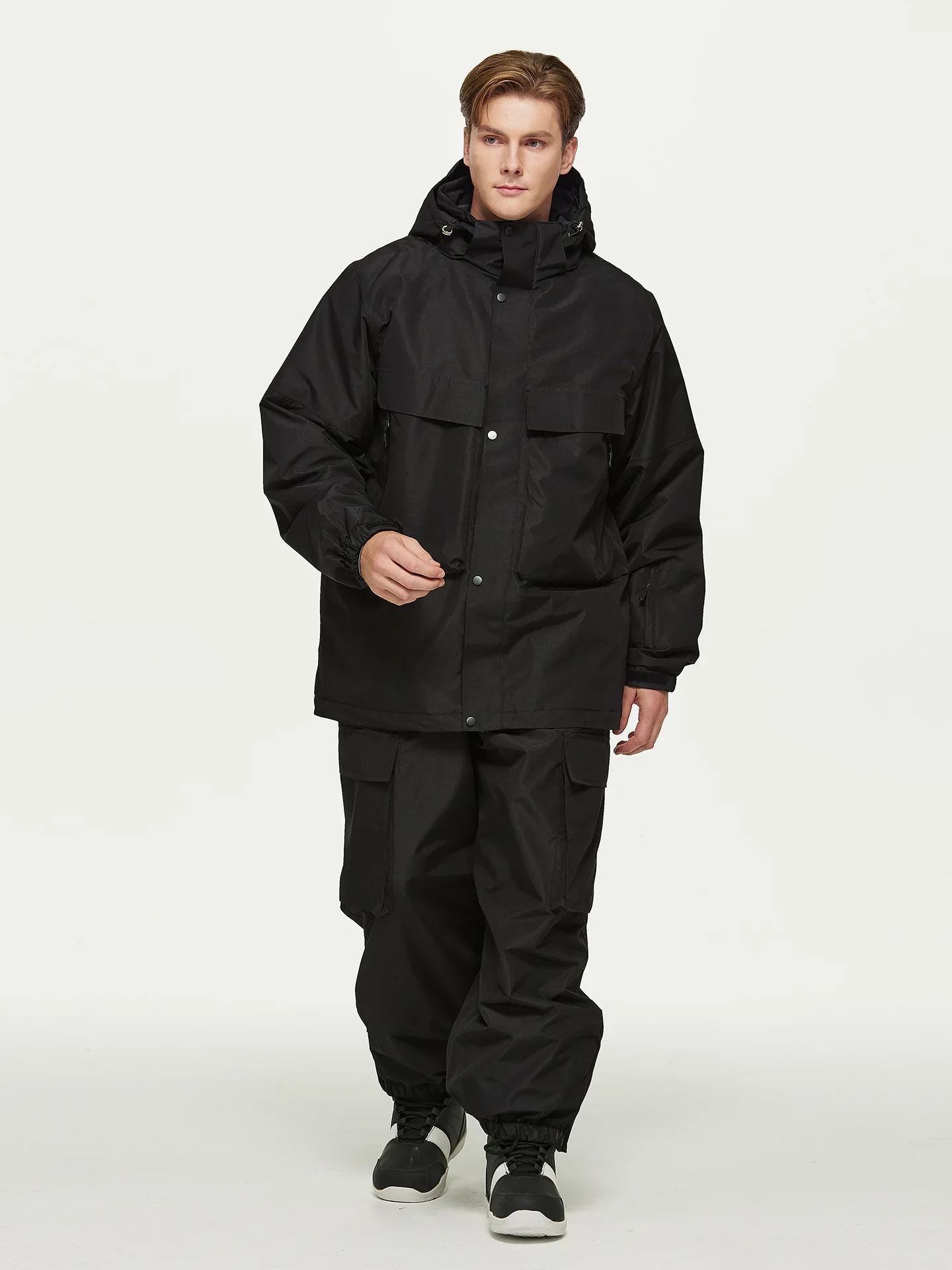 Unisex ski set in Black — insulated jacket and snow pants worn on the snow