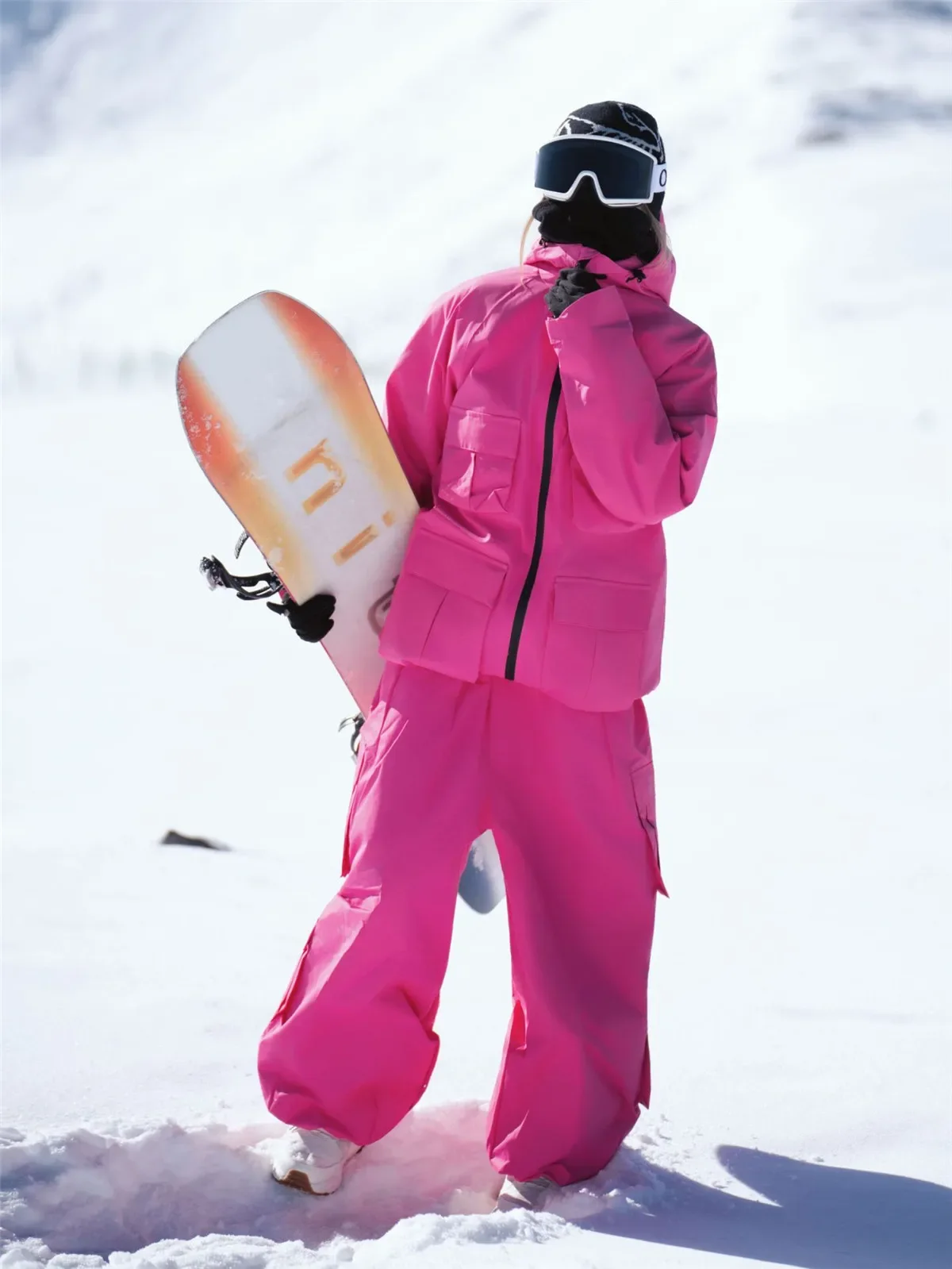 Unisex snowboard suit in Rose Red, worn on the snow