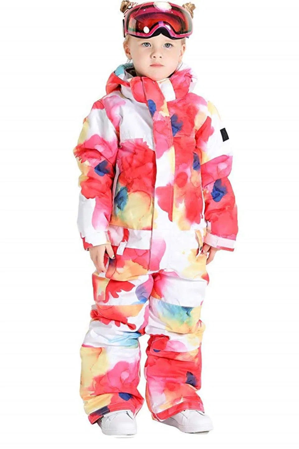 Girl wearing the watercolor print one-piece ski suit with goggles on her head, front view