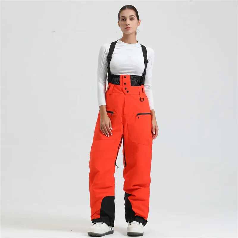 Women's ski bib pants in Orange — adjustable suspenders and a shaped fit, worn by a model
