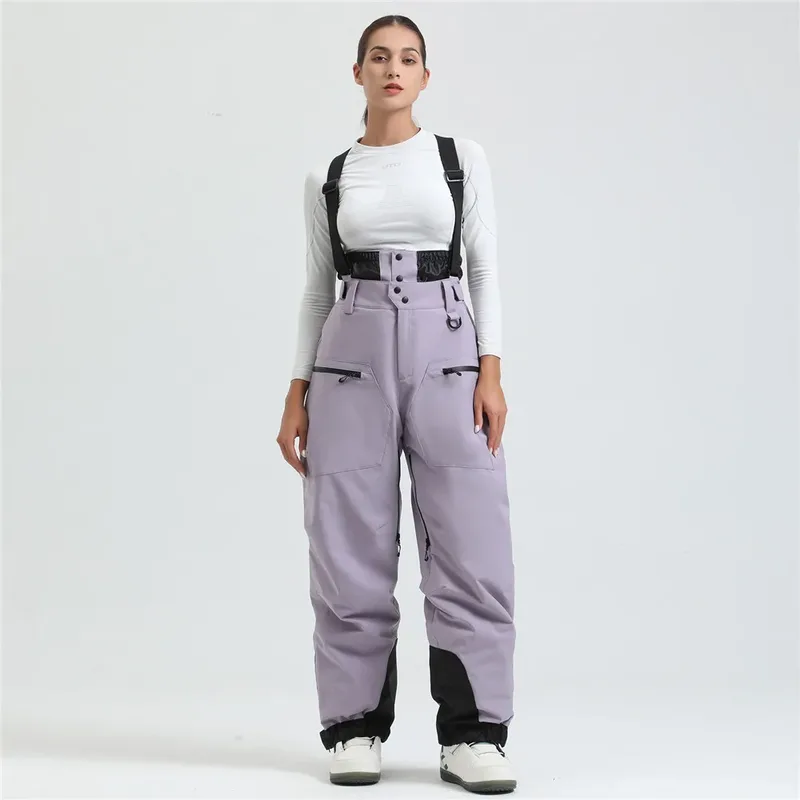 Women's ski bib pants in Violet — adjustable suspenders and a shaped fit, worn by a model